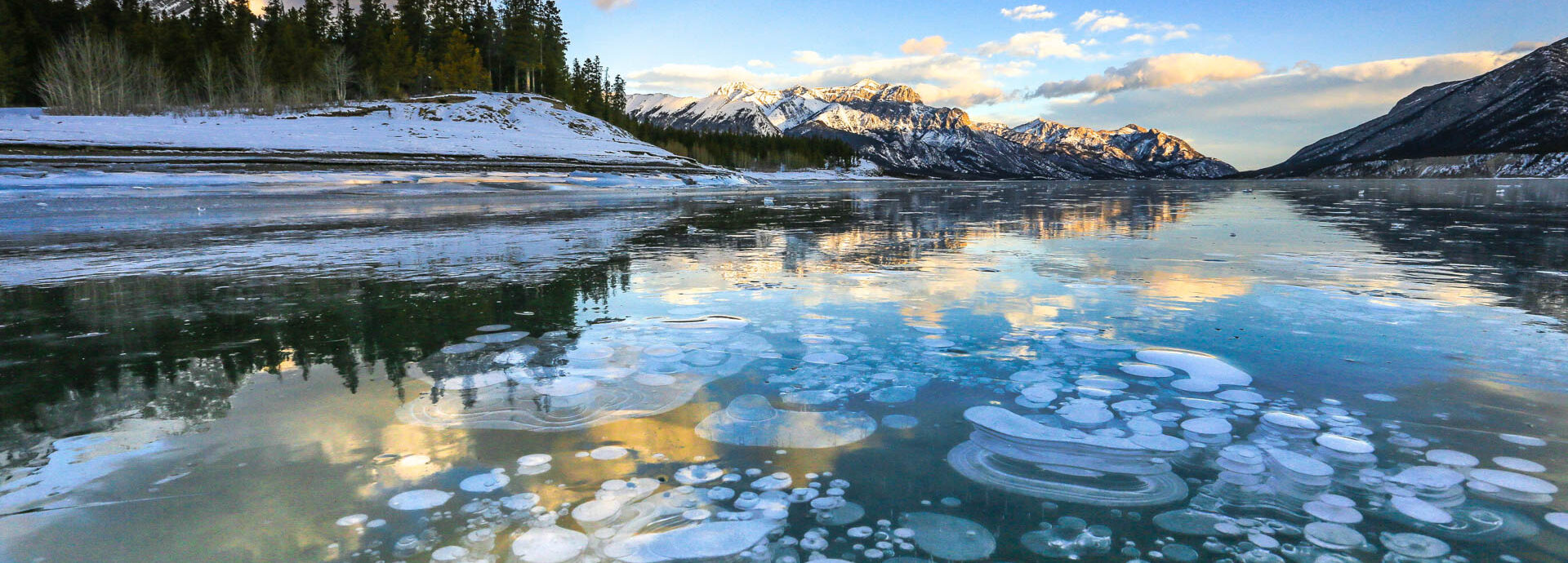 Sunset over the frozen, bubble-filled surface of Abraham Lake, Alberta