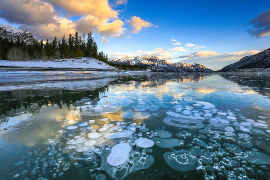 Sunset over the frozen, bubble-filled surface of Abraham Lake, Alberta